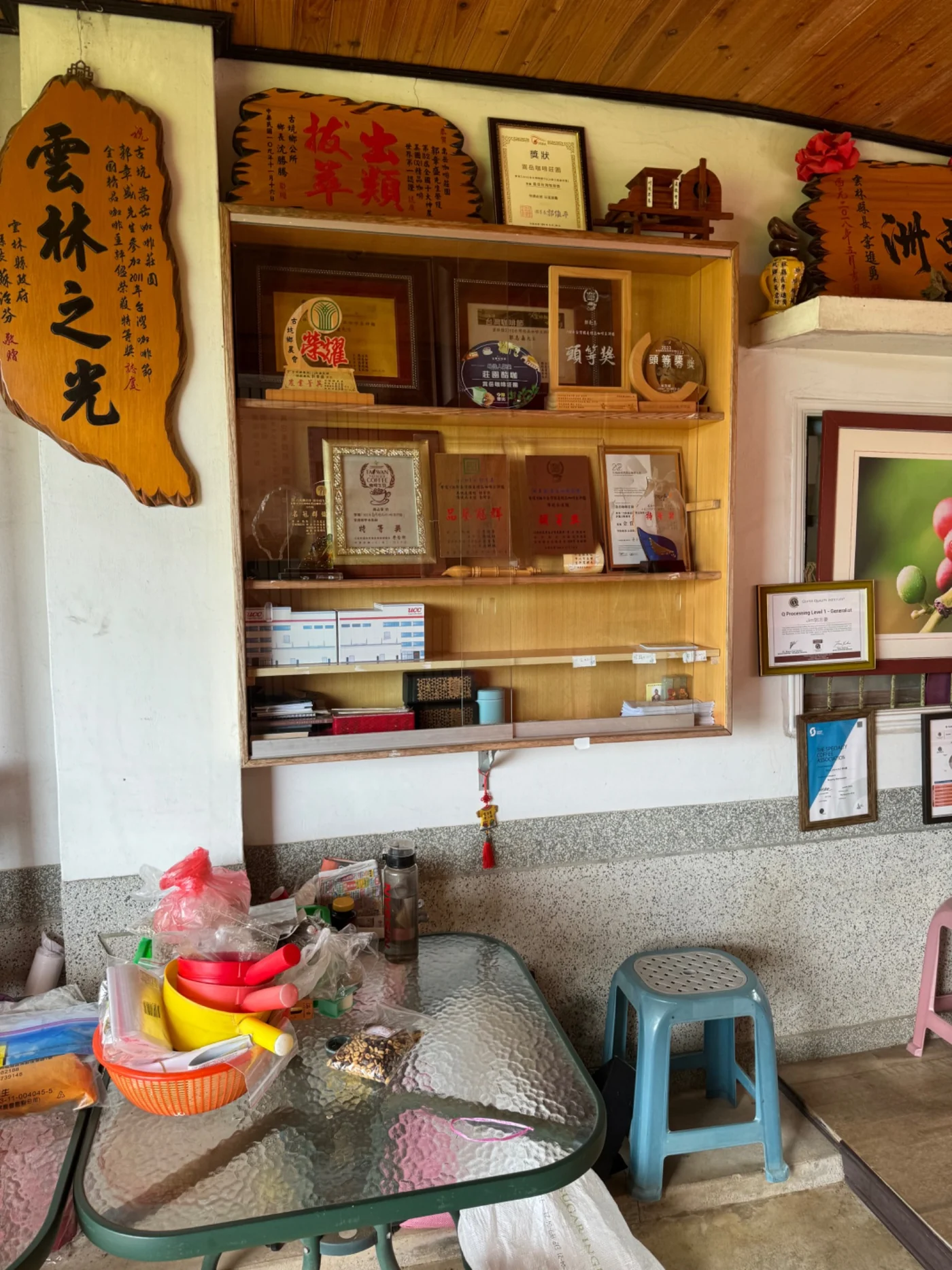 Inside a boutique mountain coffee producer in Taiwan, with coffee awards and local calligraphy displayed on the walls
